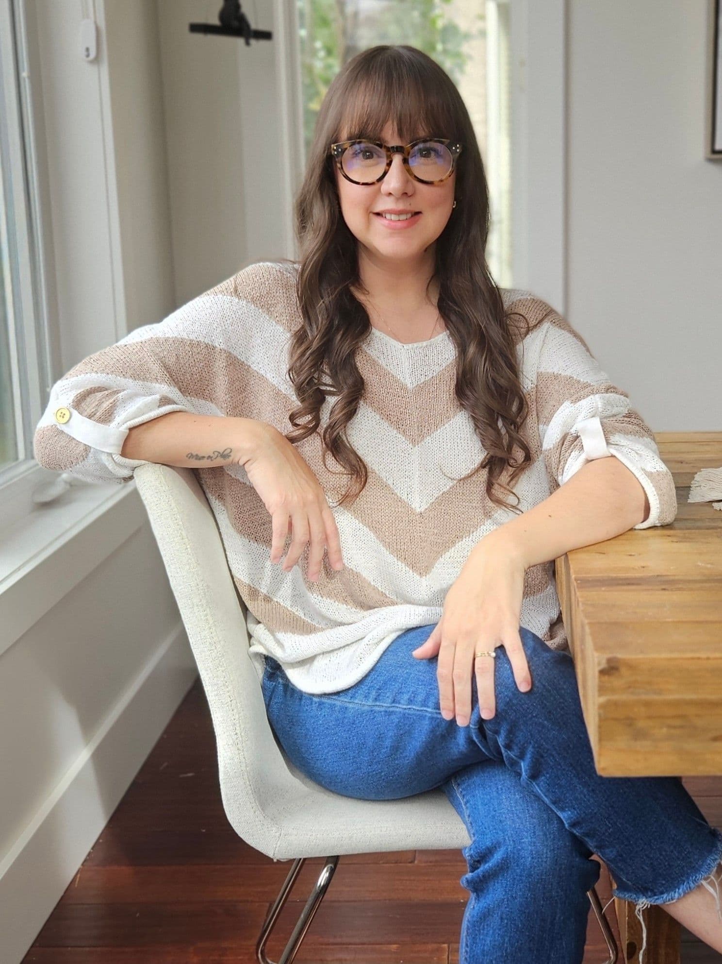 Veronica Pertuso, seated at her table by the window, smiling at the camera